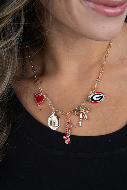 Necklace with various charms including a red heart, bow, and letter &