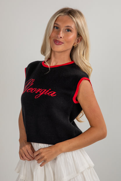 Woman wearing a black sleeveless top with red trim and &