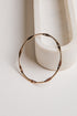 Gold hoop earring on a white surface