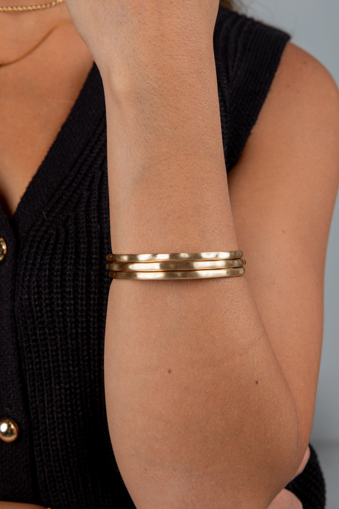Gold bracelet on a wrist with a blurred background
