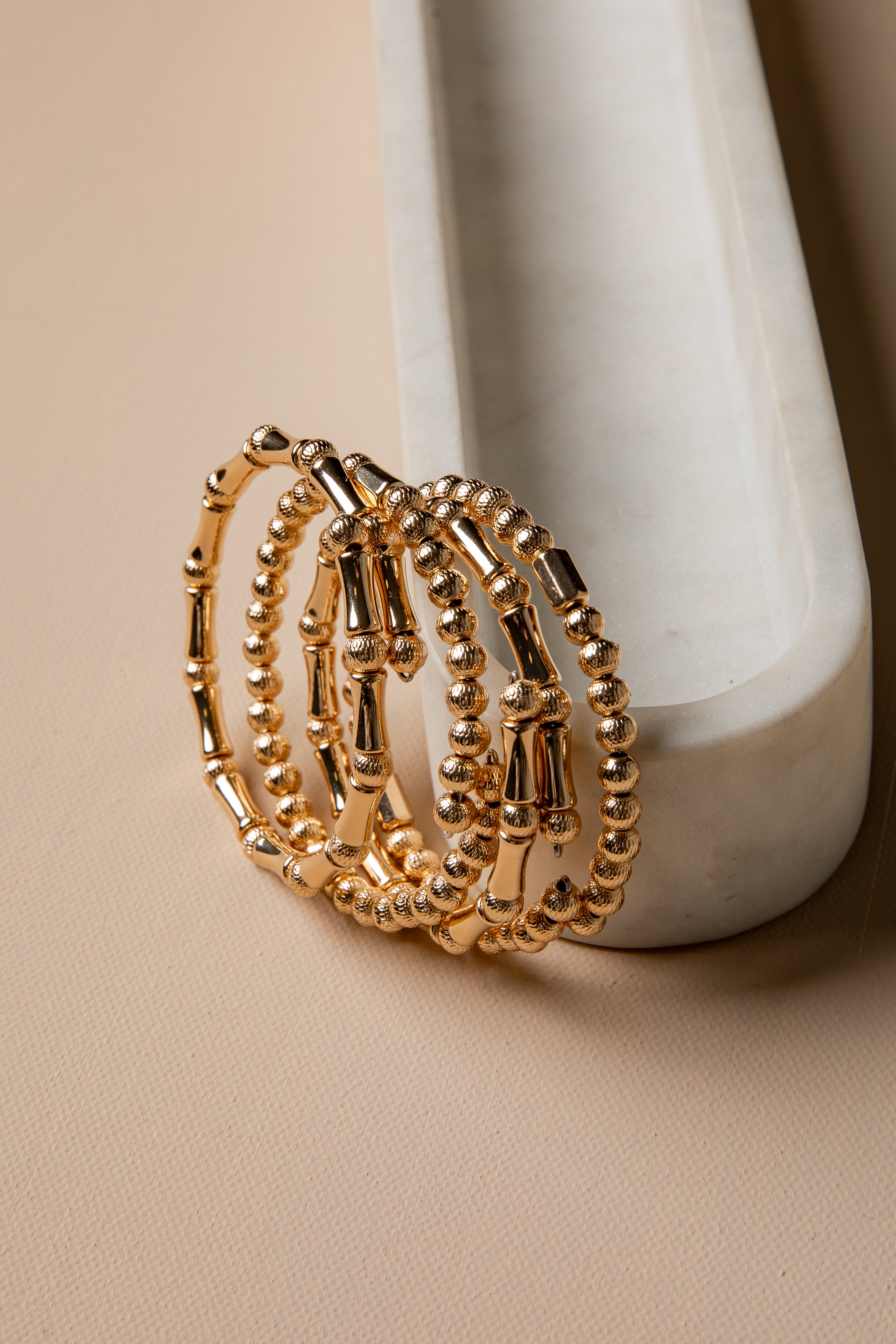 Gold hoop earrings on a marble surface