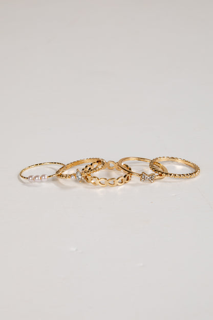 Set of gold rings with small stones on a light gray background