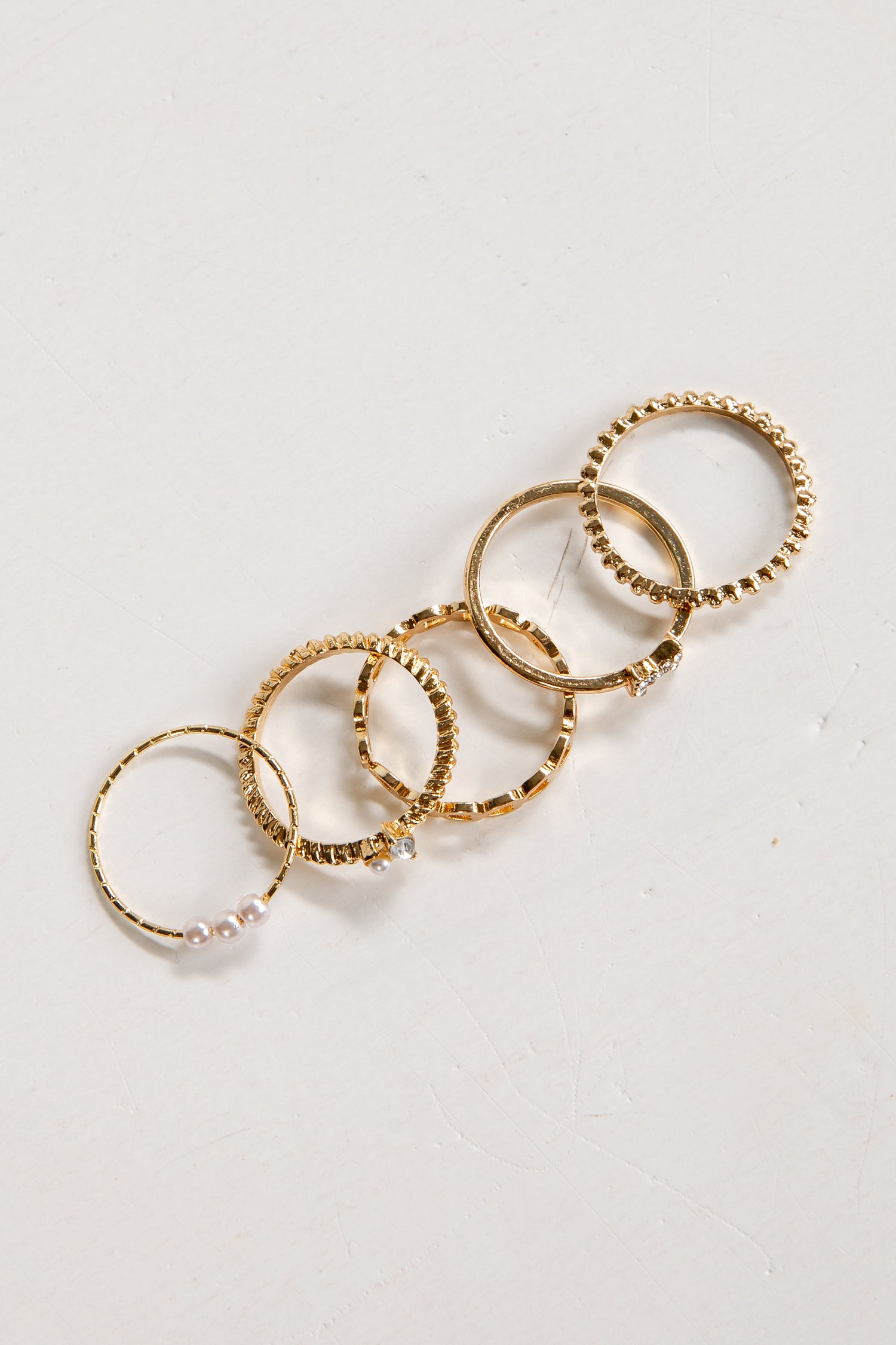 Set of gold rings on a light gray background