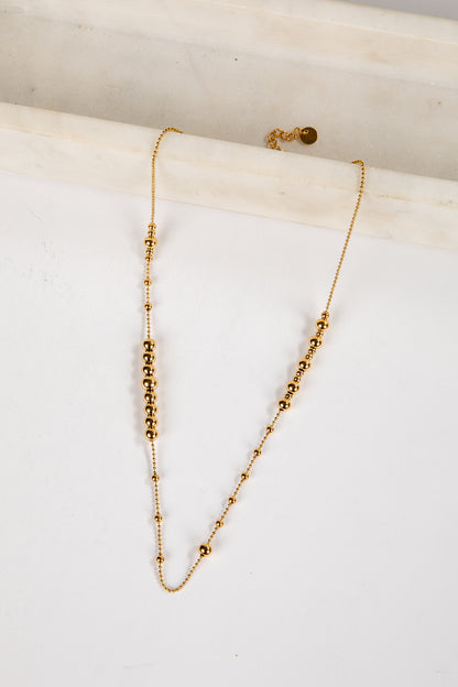 Gold necklace on a white marble surface