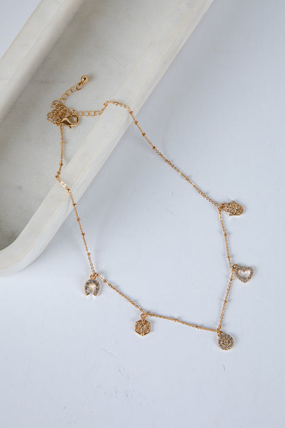 Gold bracelet with heart-shaped charms on a white surface