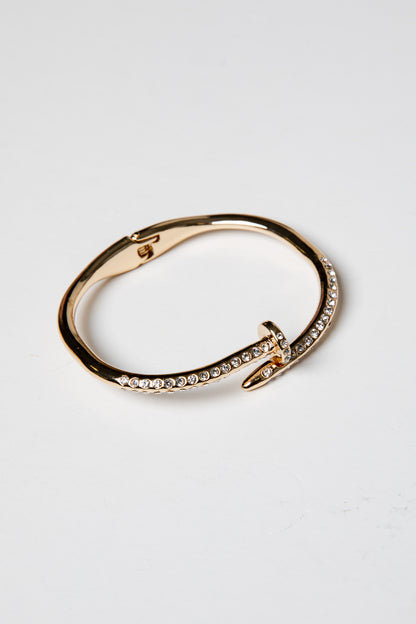 Gold bracelet with diamond accents on a light gray background