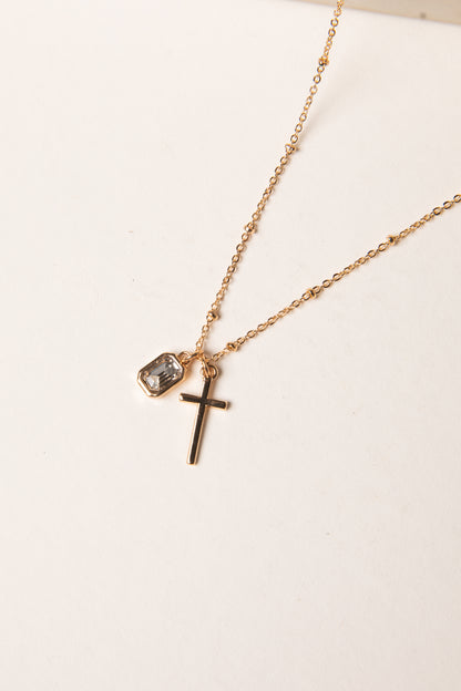 Gold necklace with a cross pendant on a white background