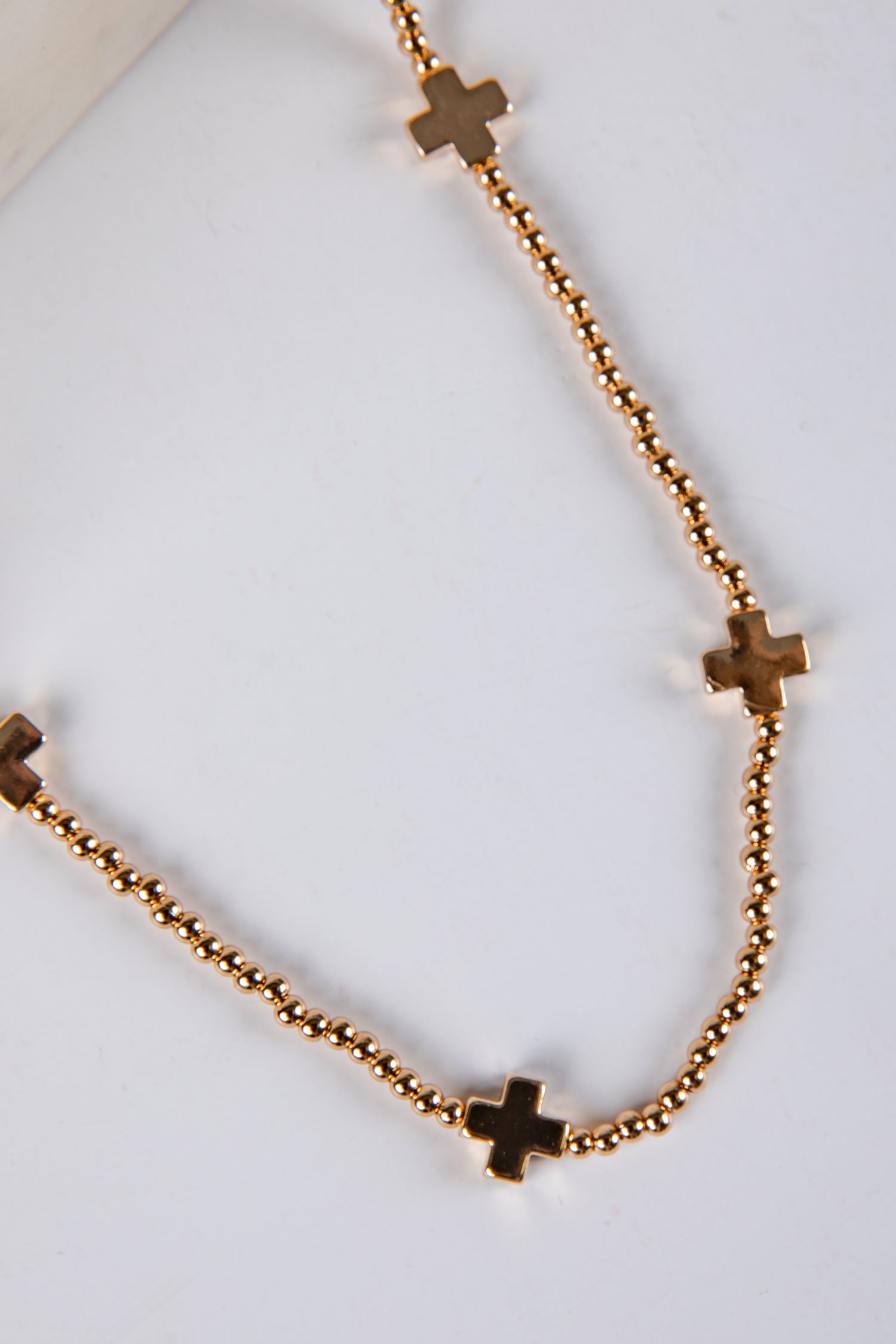 Gold necklace with cross pendants on a white background