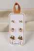 Set of earrings on a white card with a brown ribbon, against a light background