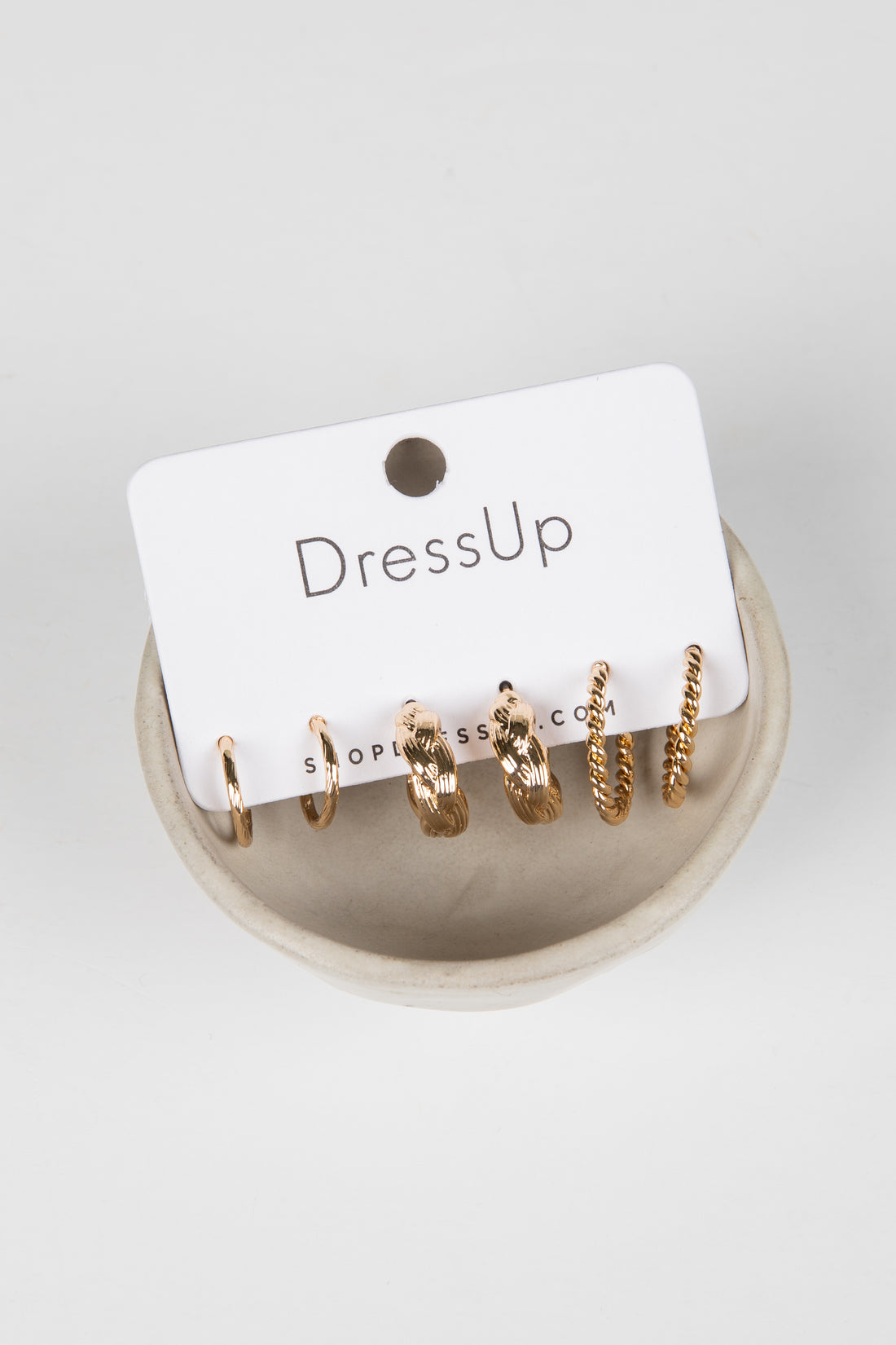 Set of gold hoop earrings on a &