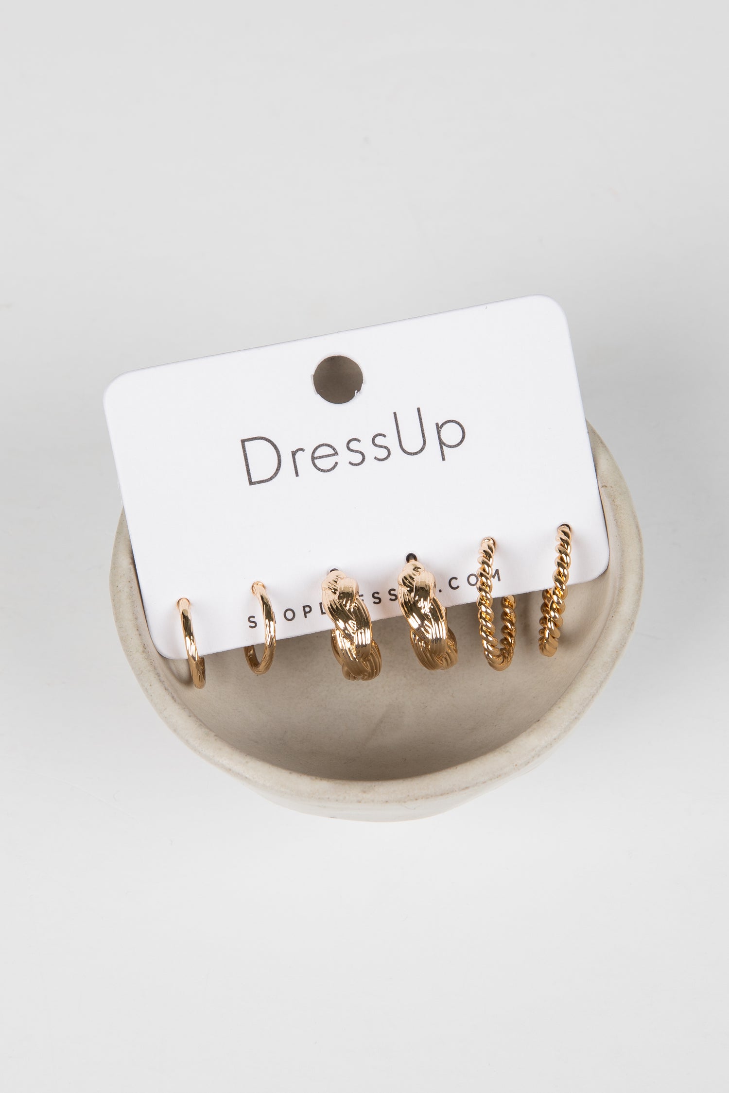 Set of gold hoop earrings on a &