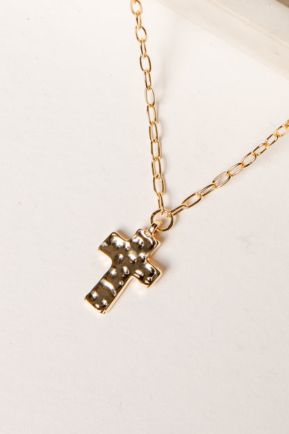 Gold cross necklace on a white background