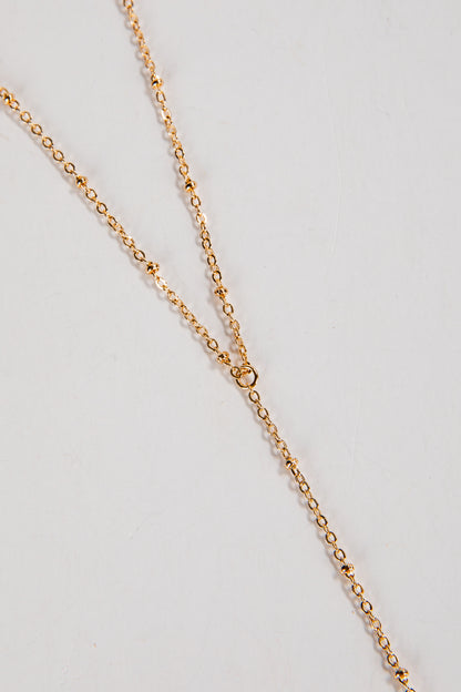 Gold chain necklace on a light gray background