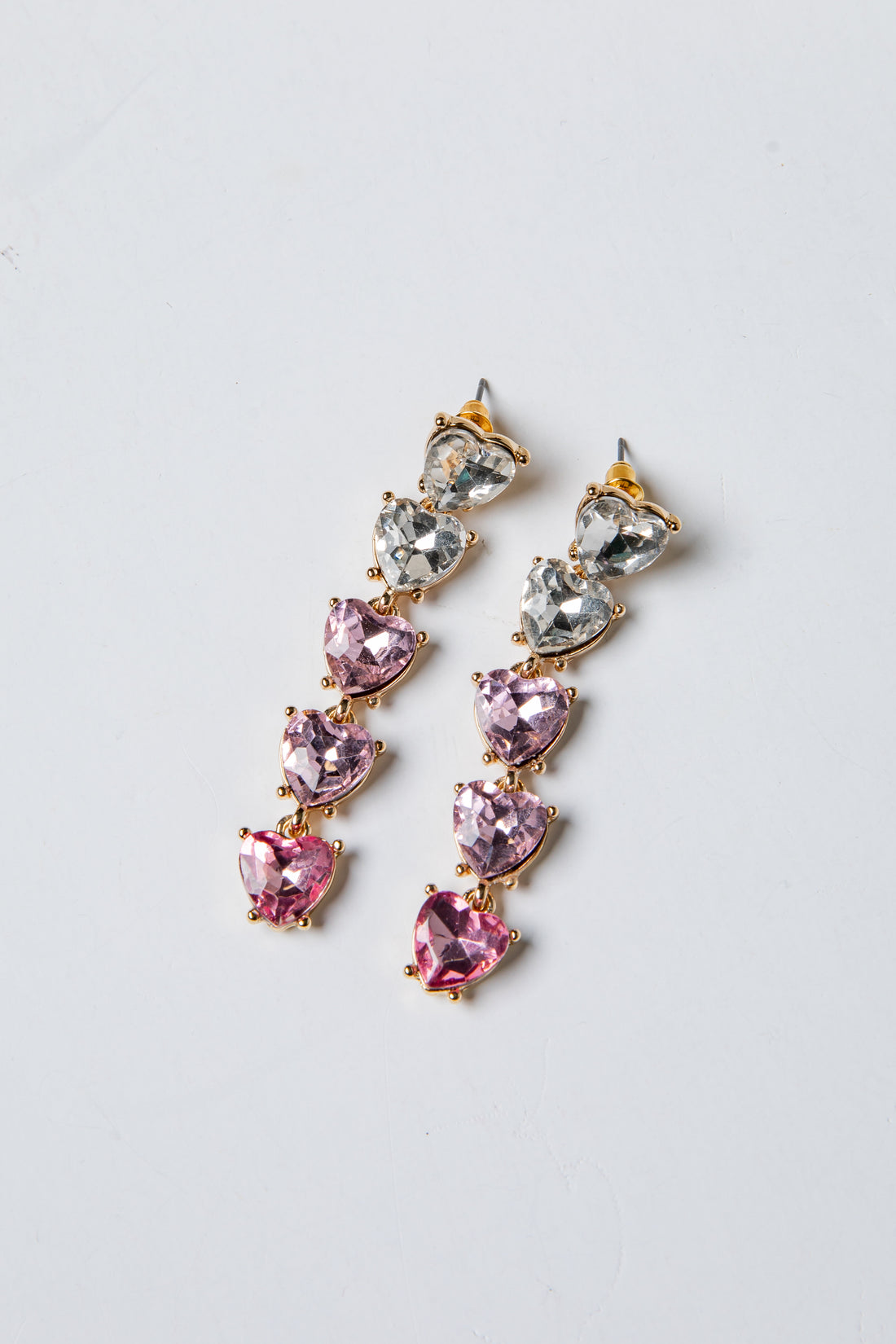 Pair of pink and silver drop earrings on a light gray background