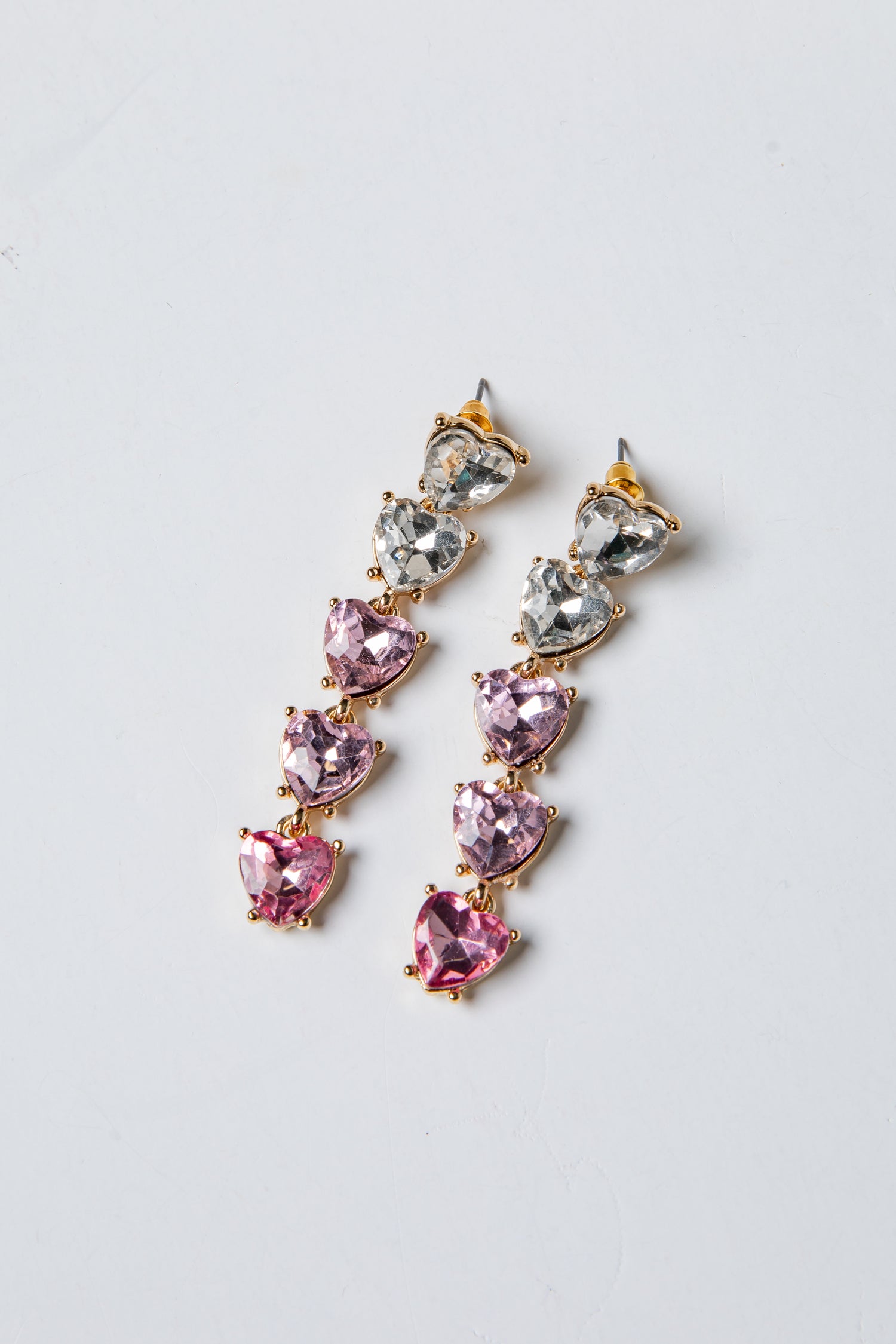 Pair of pink and silver drop earrings on a light gray background