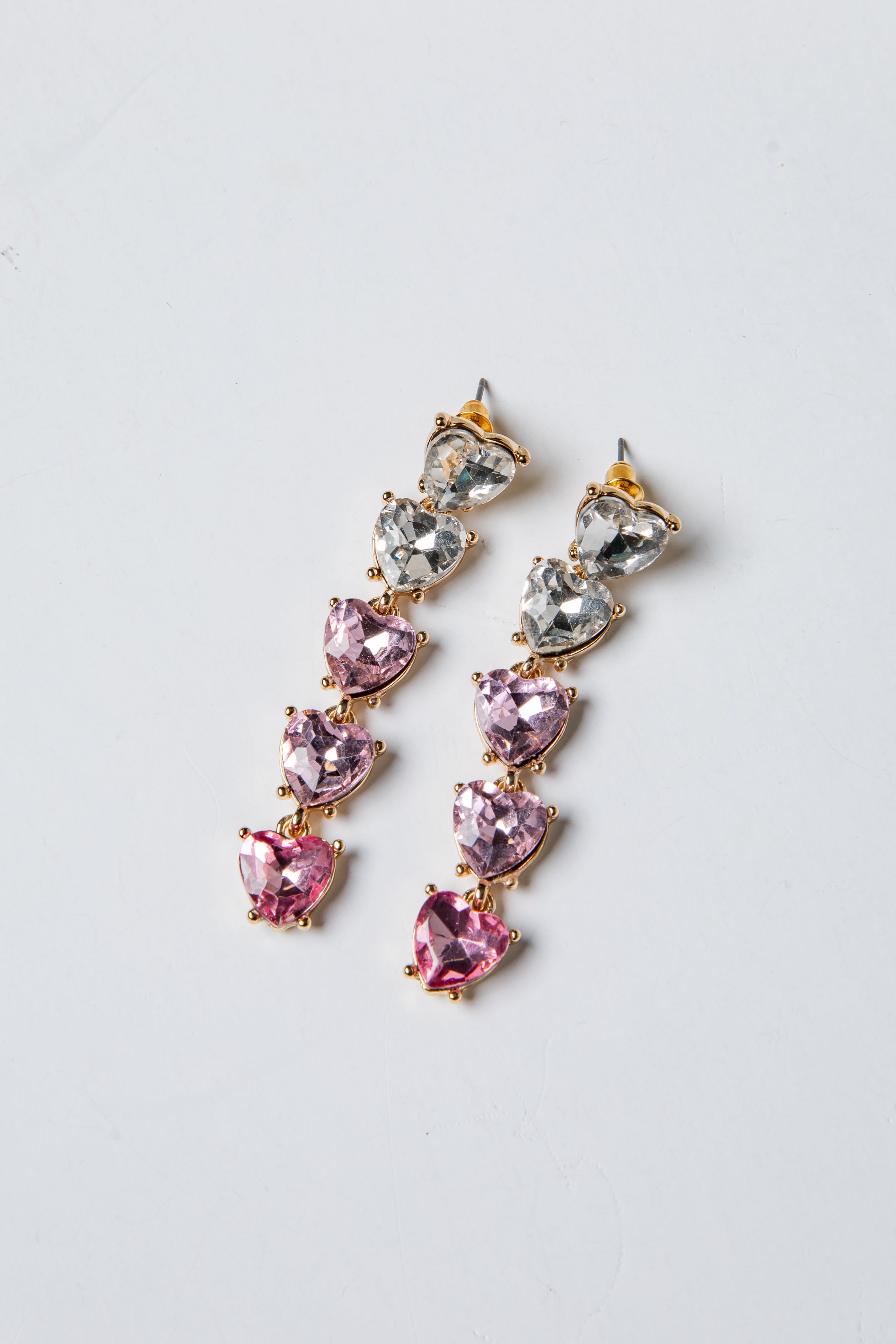 Pair of pink and silver drop earrings on a light gray background