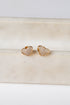Heart-shaped gold earrings on a marble surface