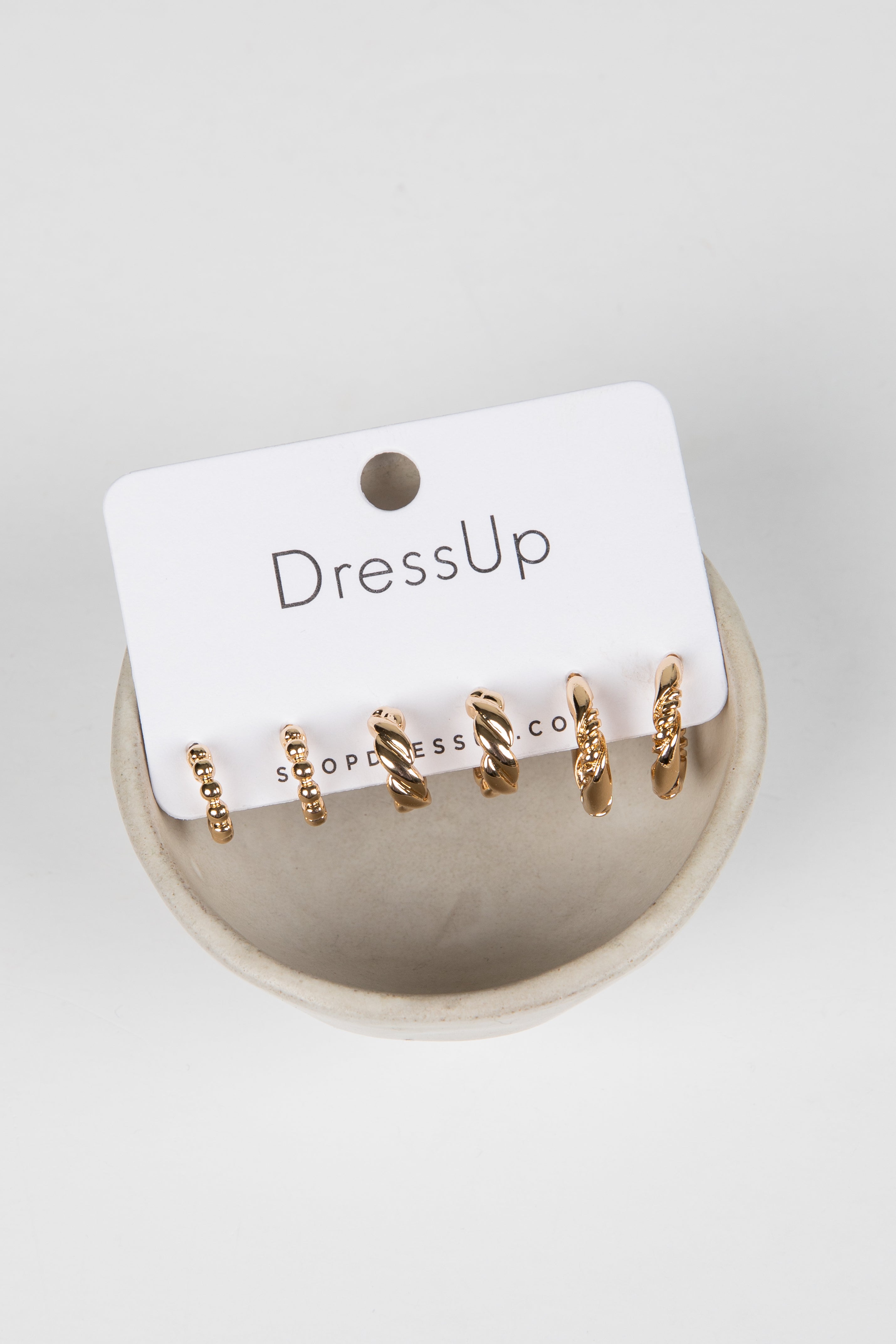 Set of gold hoop earrings on a &