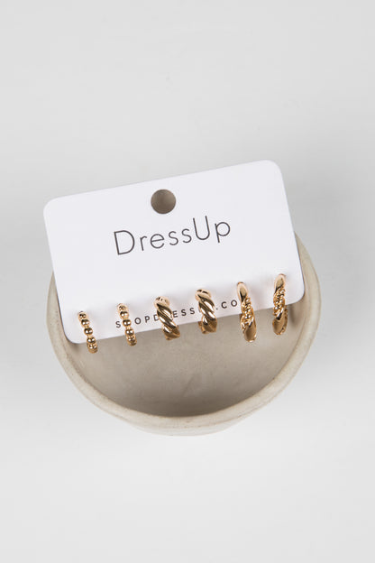 Set of gold hoop earrings on a &