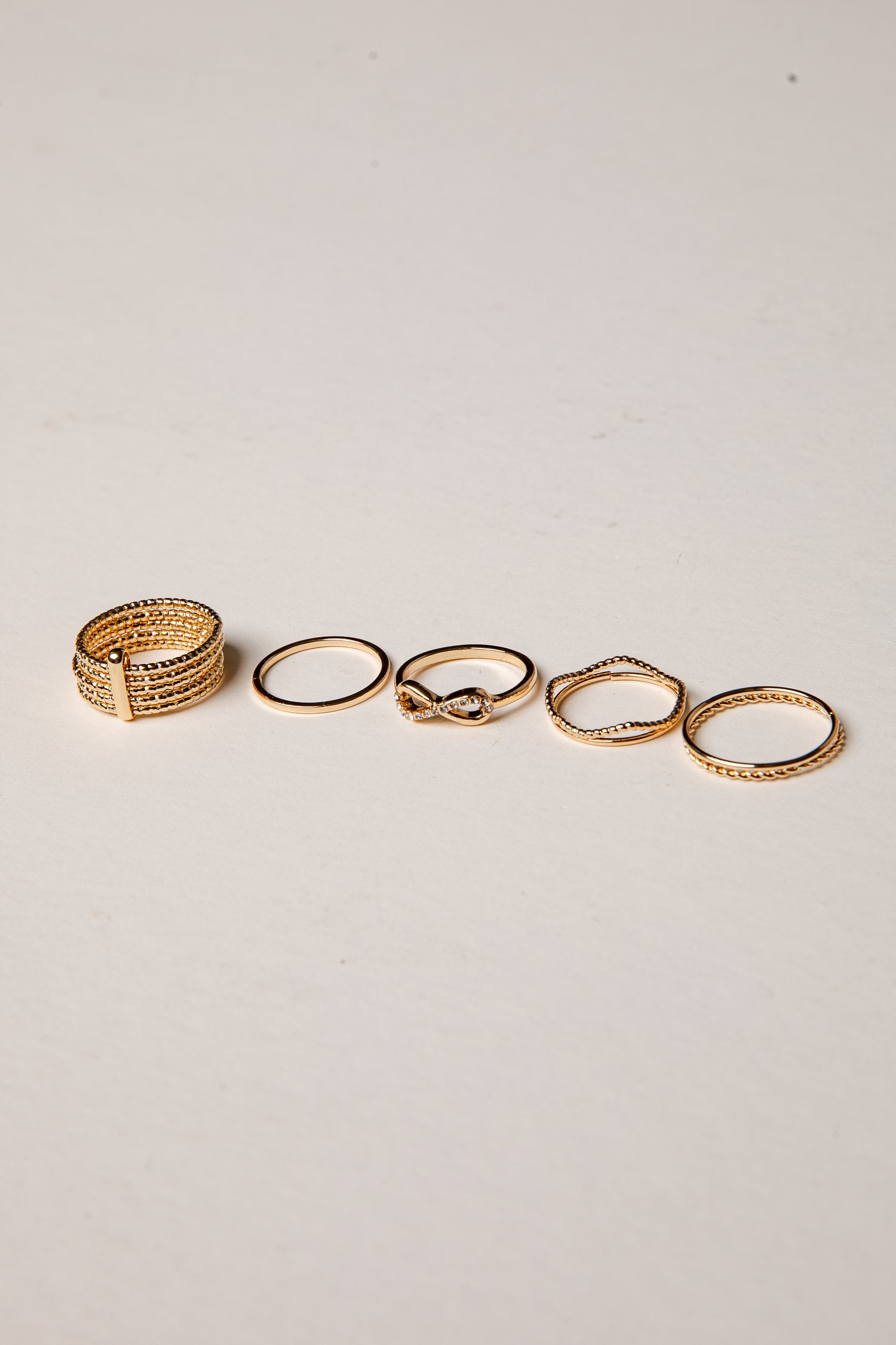 Set of gold rings on a light gray background