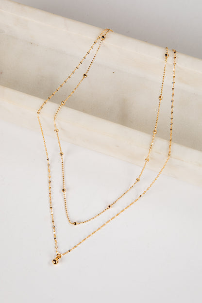 Gold necklace on a white surface