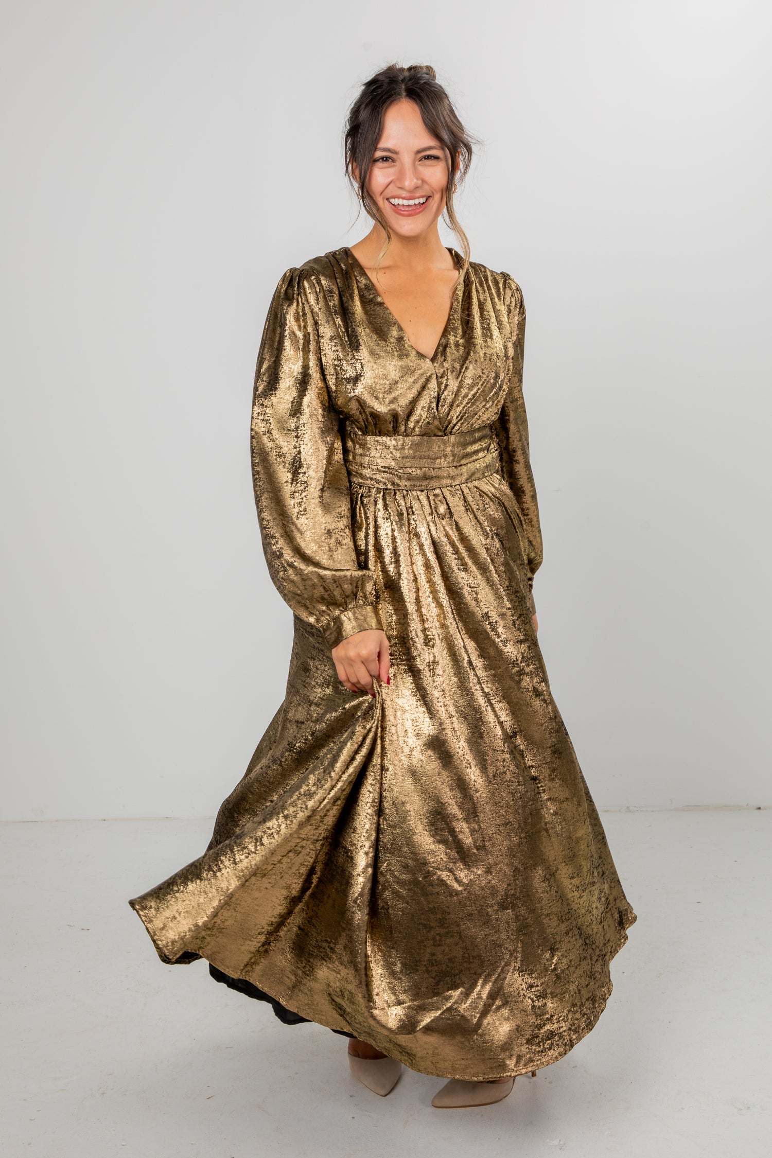 Woman wearing a gold metallic dress on a white background