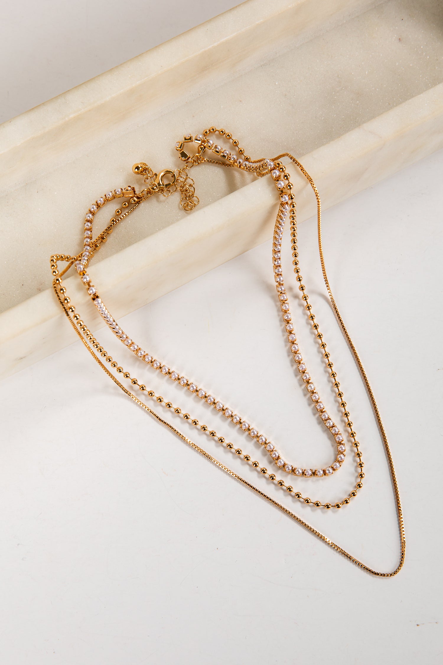 Gold necklace on a light wooden surface