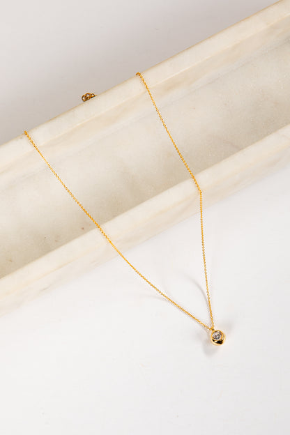 Gold necklace on a white marble surface