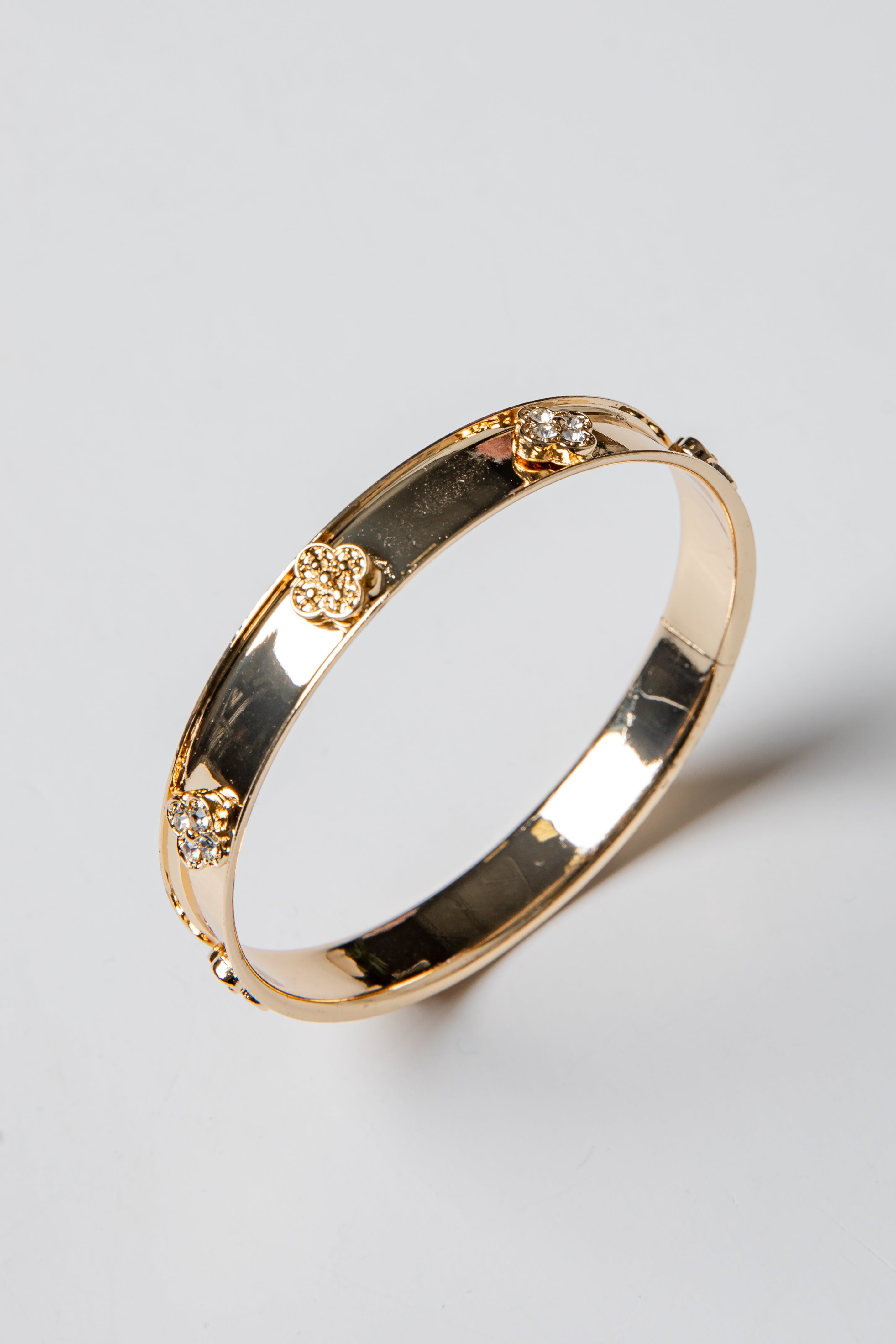 Gold bracelet with diamond accents on a light gray background