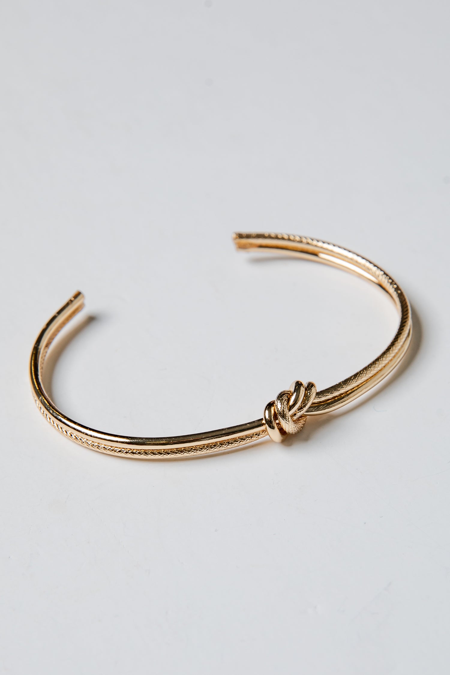 Gold bracelet on a light gray background