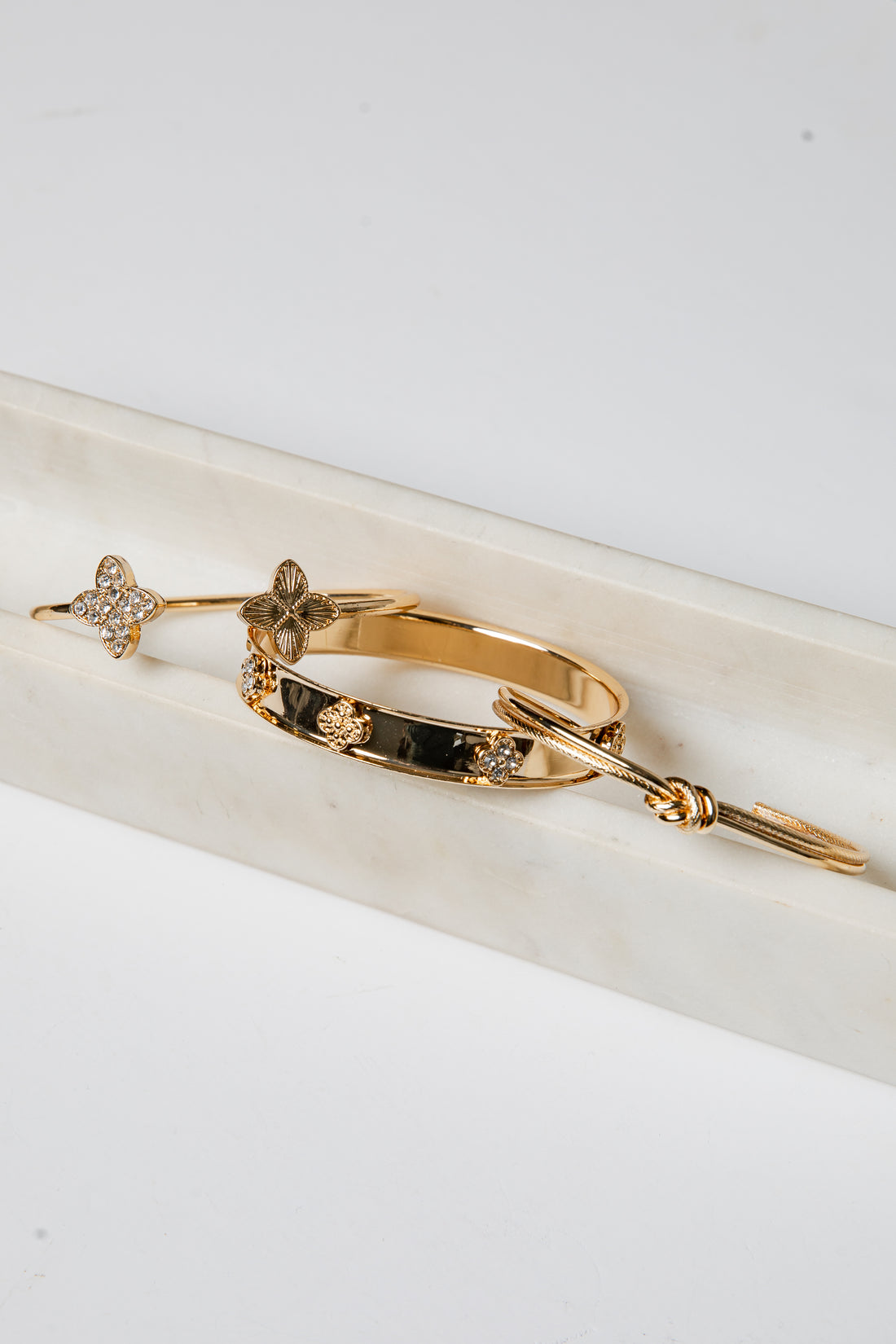 Gold bracelet with embedded stones on a white surface