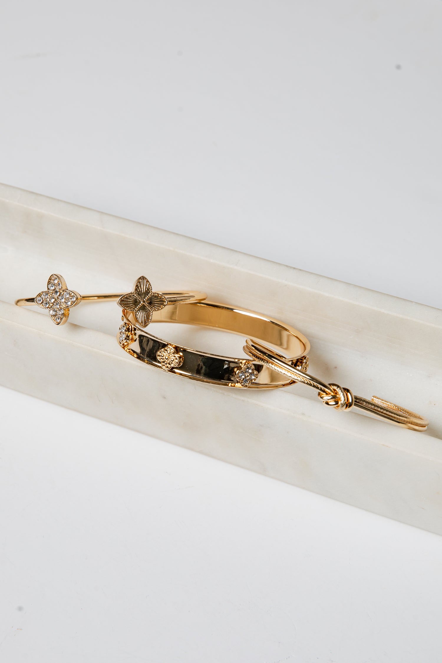 Gold bracelet with embedded stones on a white surface
