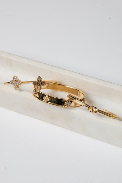 Gold bracelet with embedded stones on a white surface