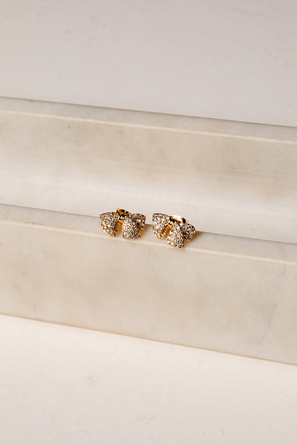 Gold earrings on a white surface