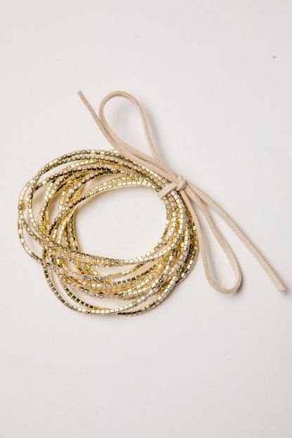 Stack of gold beaded bracelets on a light background