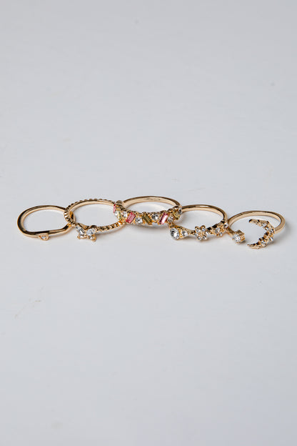 Set of gold rings with various designs on a light gray background