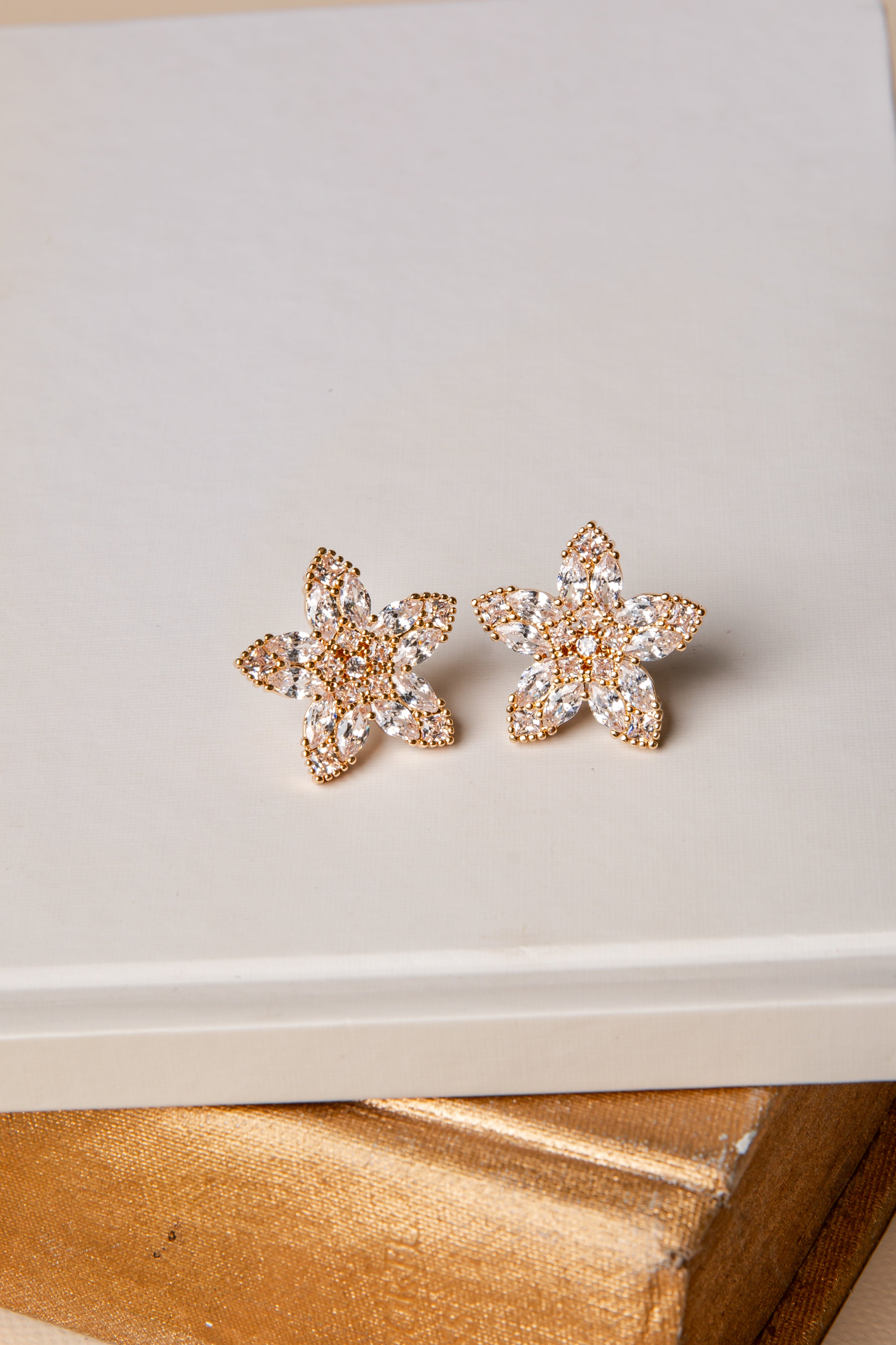 Star-shaped earrings with rhinestones on a light surface