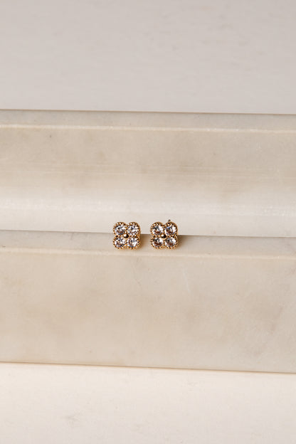Pair of gold earrings with clear stones on a white background