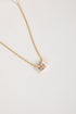 Gold necklace with a star-shaped pendant on a light gray background