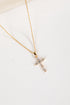 Gold cross necklace with small diamonds on a white background