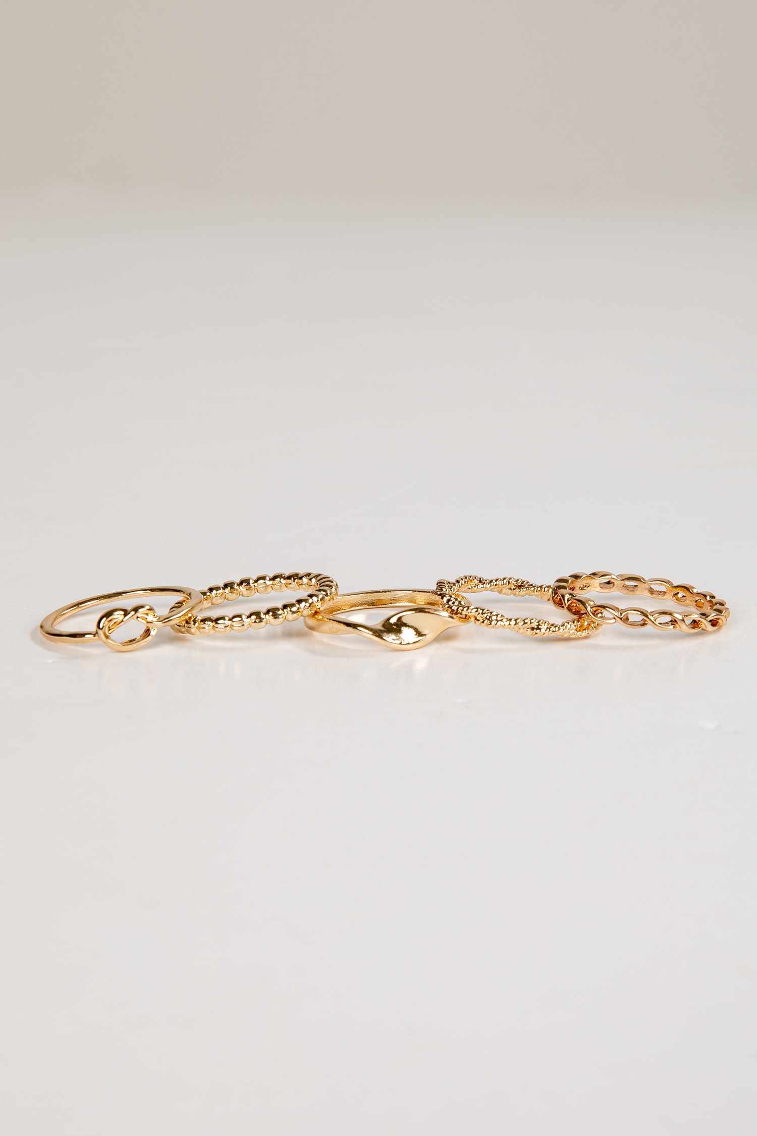 Set of gold rings on a light gray background