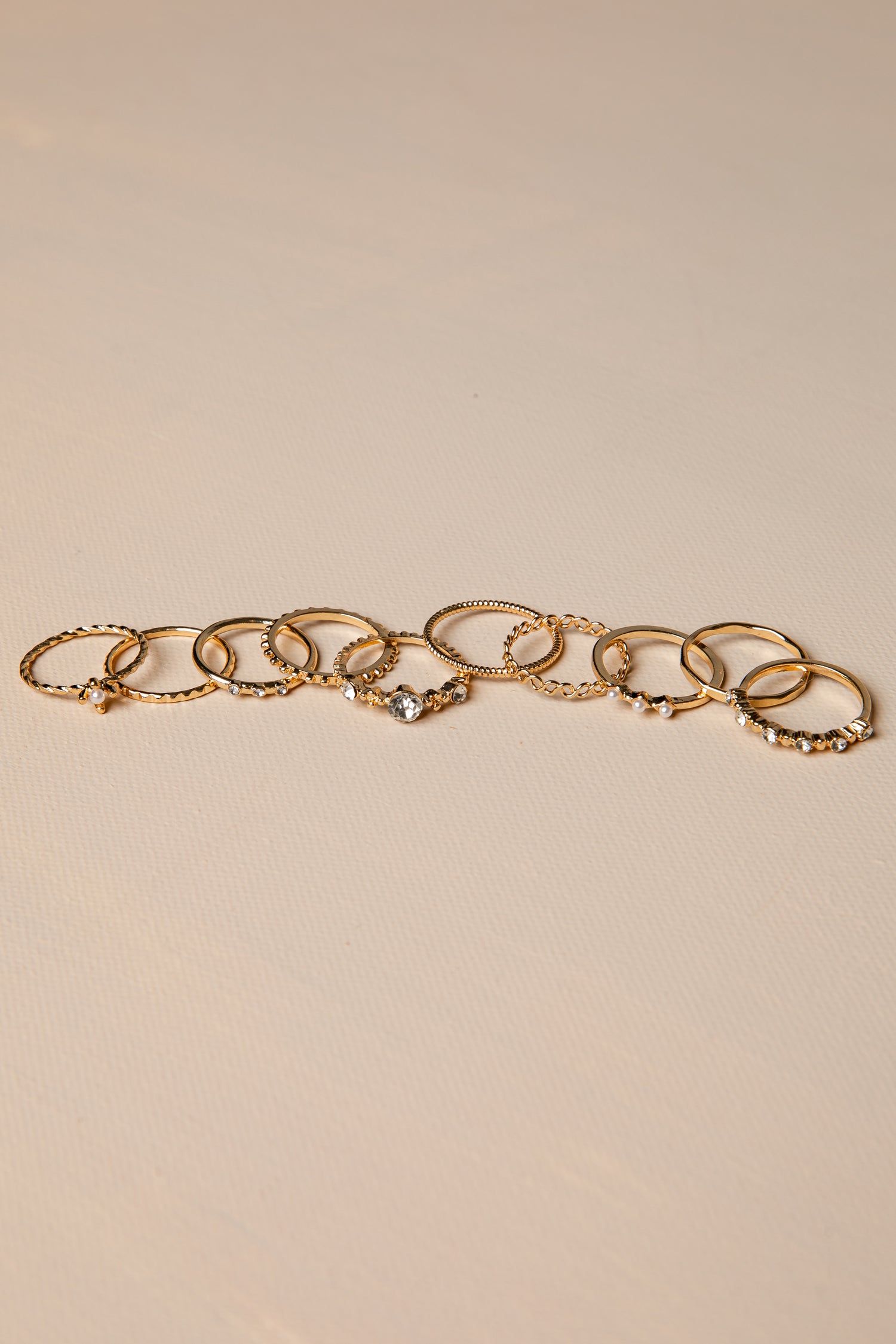 Gold rings with charms on a beige background