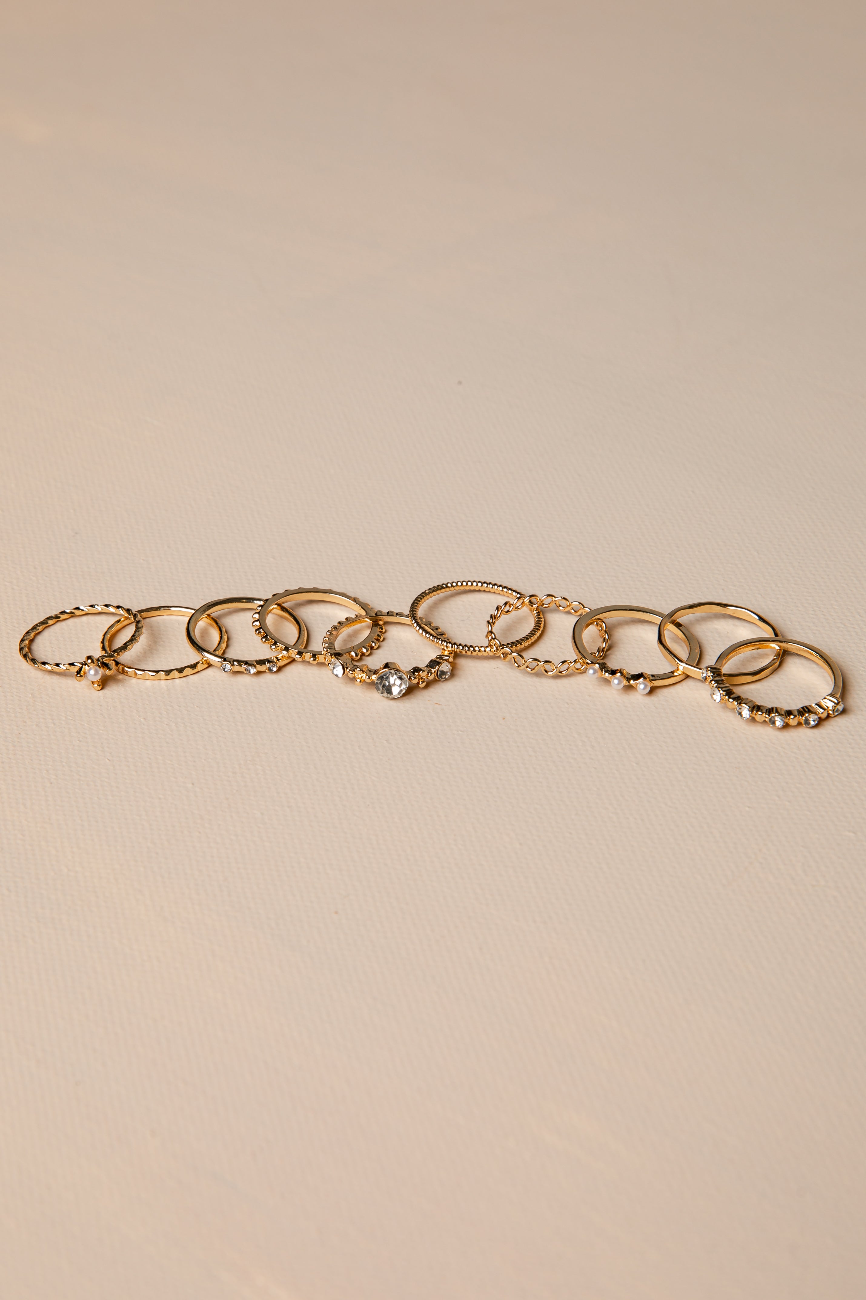 Gold rings with charms on a beige background