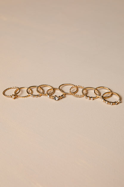 Gold rings with charms on a beige background