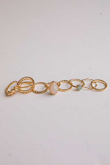 Gold bracelet with three beads on a light gray background