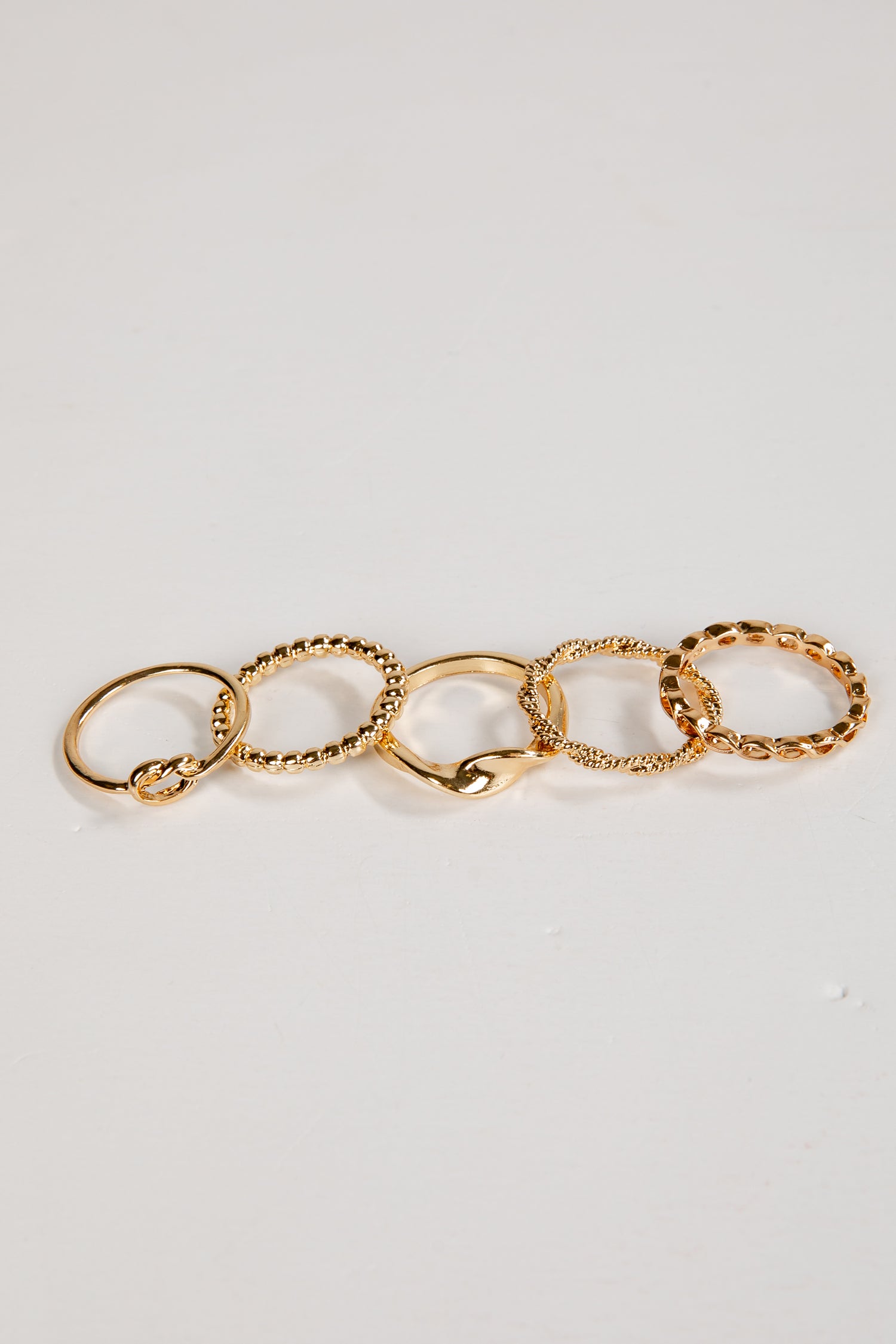 Set of gold rings on a light gray background