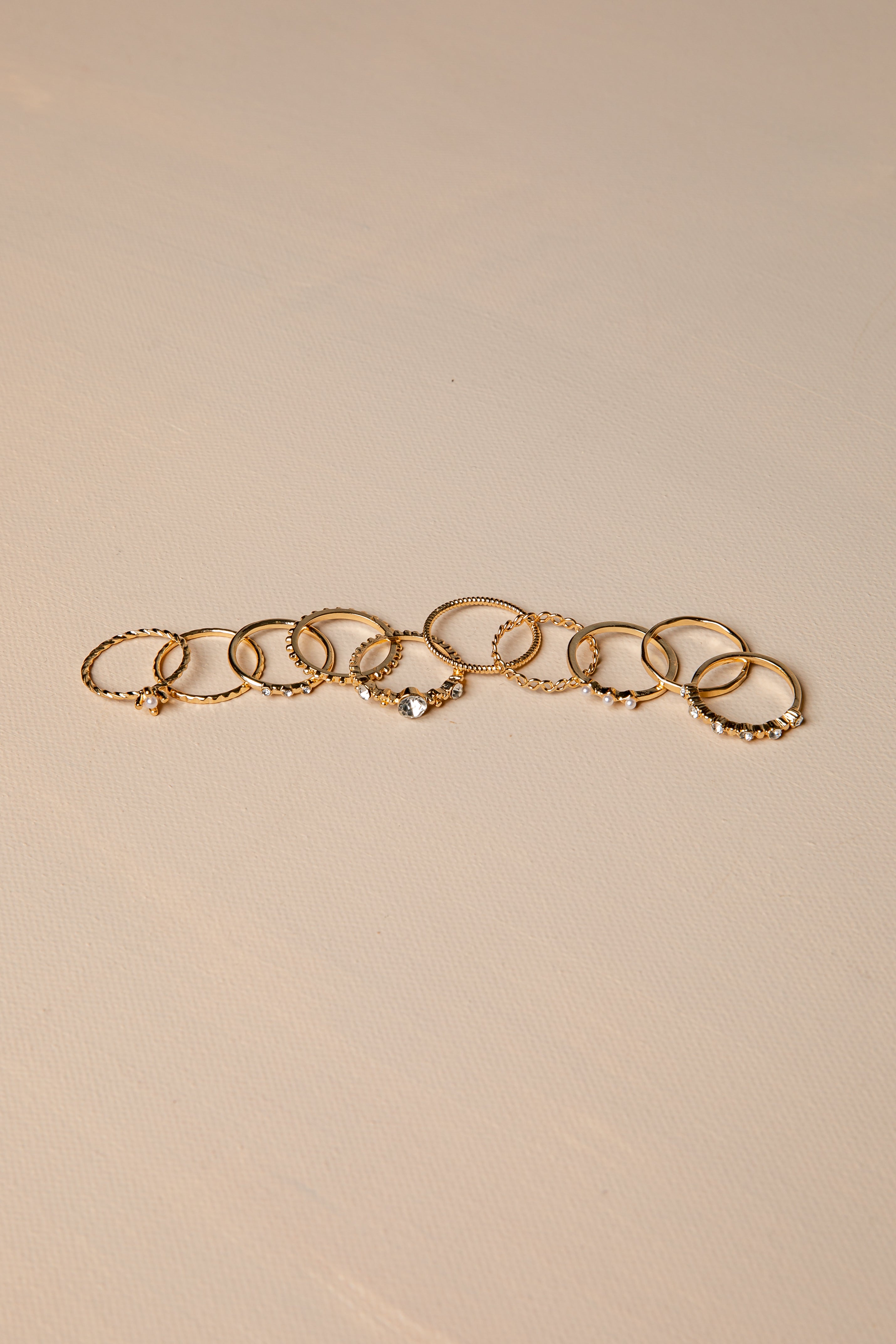Gold rings with multiple rings on a beige background