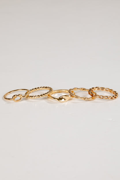 Set of gold chain rings on a light gray background