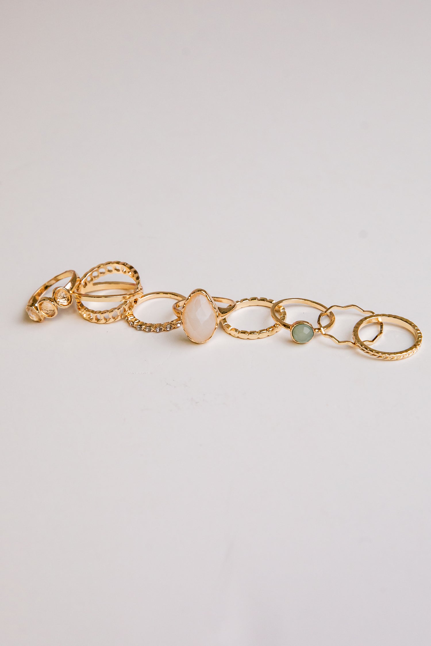 Gold bracelet with stones on a light gray background