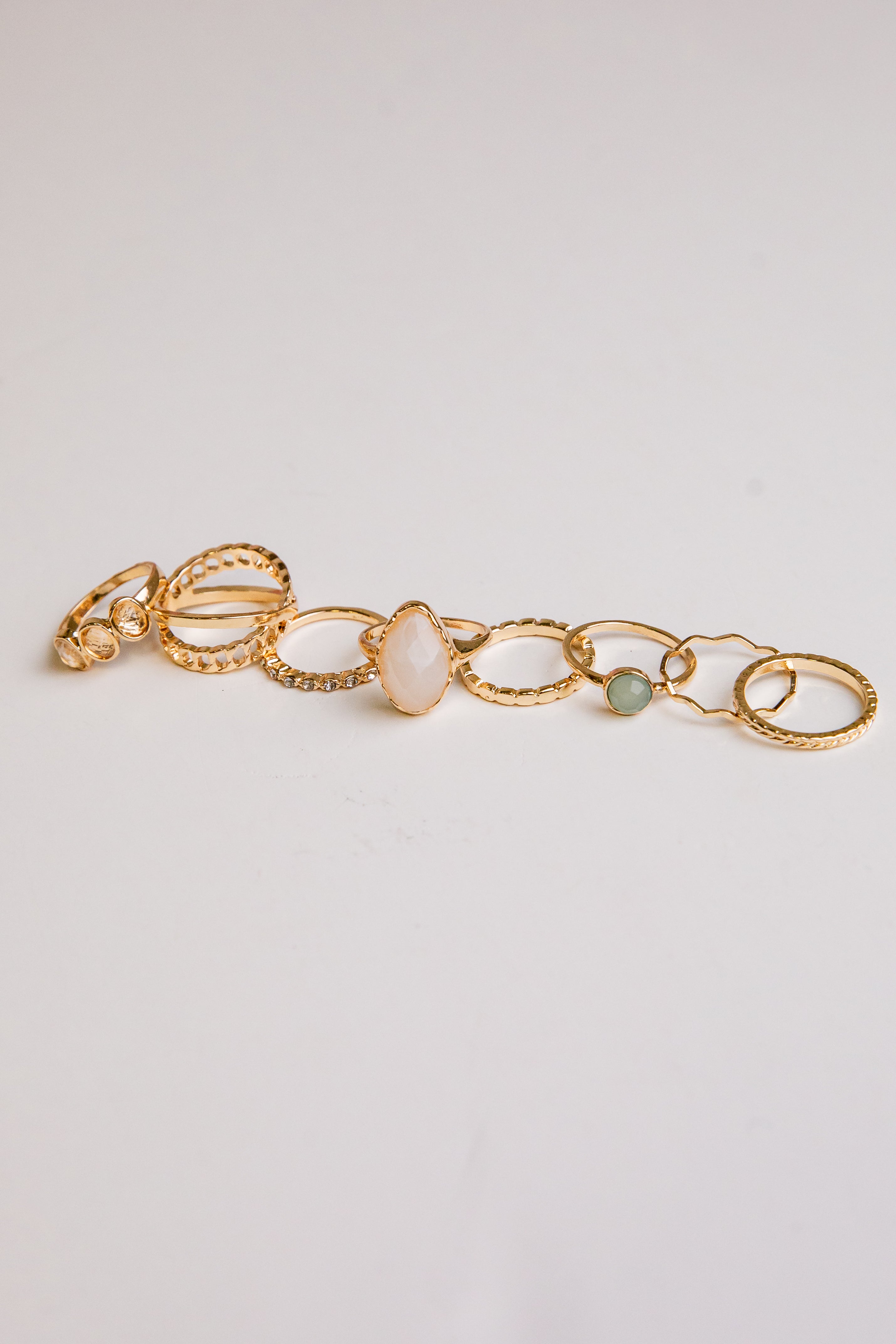 Gold bracelet with stones on a light gray background